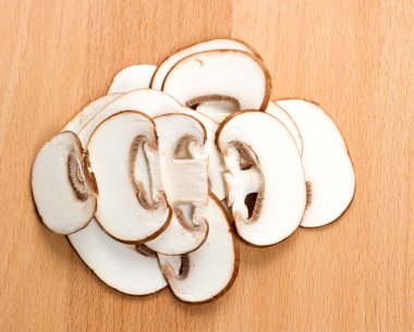 Kesme tahtasında dilimlenmiş mantarlar.