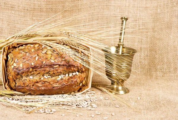 Organic grain bread on burlap background — Stock Photo, Image