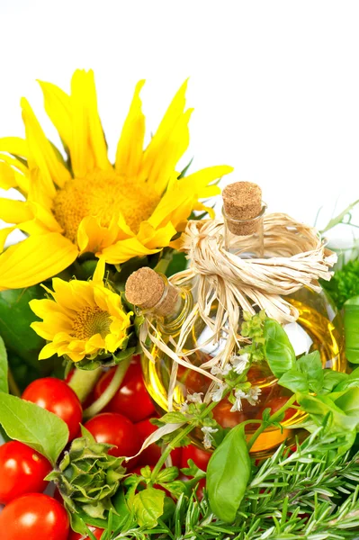 Erbe aromatiche con pomodori, girasoli e bottiglia di olio vegetale — Foto Stock