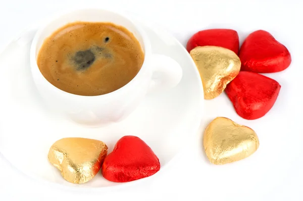 Xícara de café preto com corações de chocolate vermelho e dourado — Fotografia de Stock