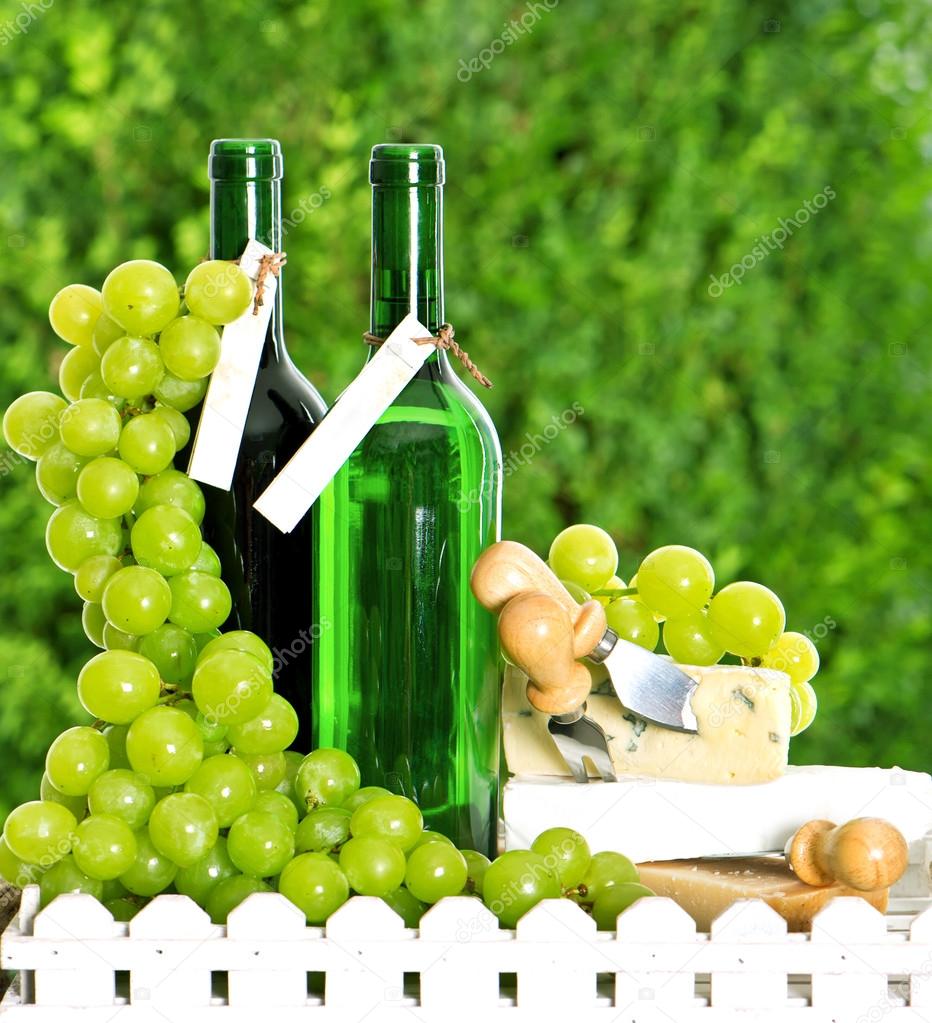 Bottle of wine, cheese and grapes