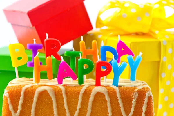 Proficiat met je verjaardag. verjaardagscake met brief kaarsen en geschenken — Stockfoto