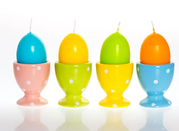 Huevos de Pascua multicolores velas en copas de huevo — Foto de Stock