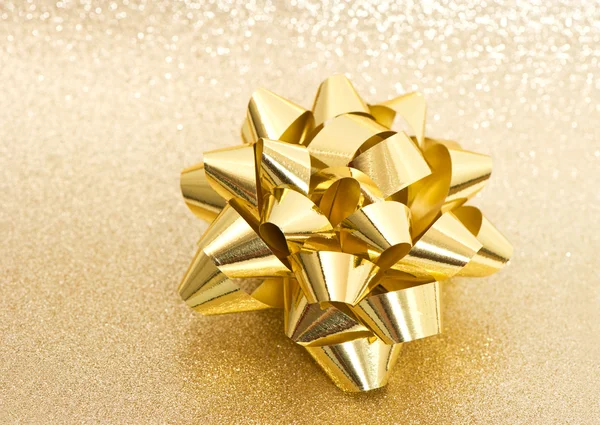 Beautiful bow on shiny golden background — Stock Photo, Image