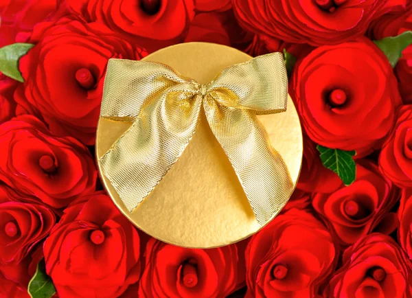 Red roses and golden gift box with ribbon — Stock Photo, Image