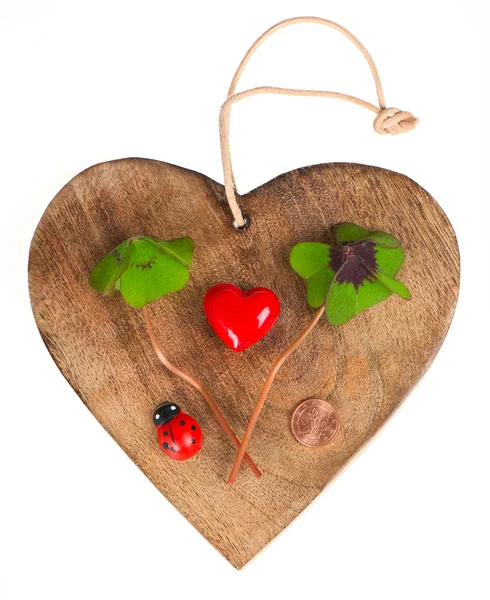 Деревянное сердце с символами удачи — стоковое фото