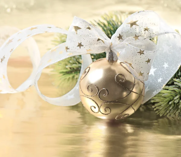 Golden christmas ball with christmas tree branch — Stock Photo, Image