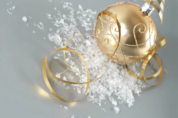 Goldene Weihnachtskugel mit goldener Luftschlange — Stockfoto