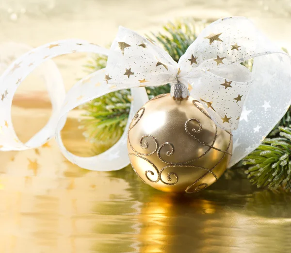 Golden christmas ball with christmas tree branch — Stock Photo, Image
