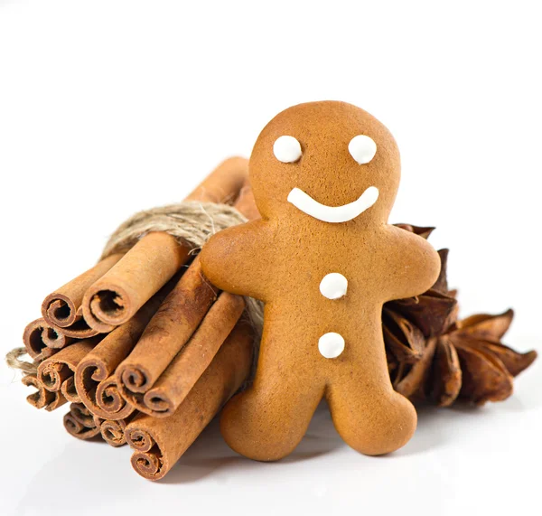 Smiling gingerbread man with christmas spices — Stock Photo, Image