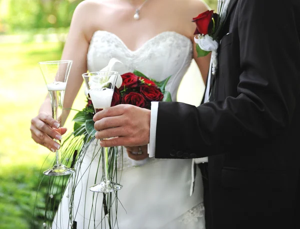 Pareja de boda sosteniendo copas de champán — Foto de Stock