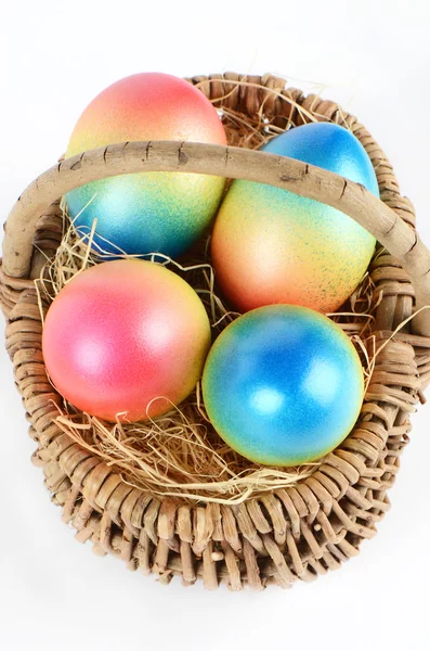 Colorful painted easter eggs in brown basket — Stock Photo, Image