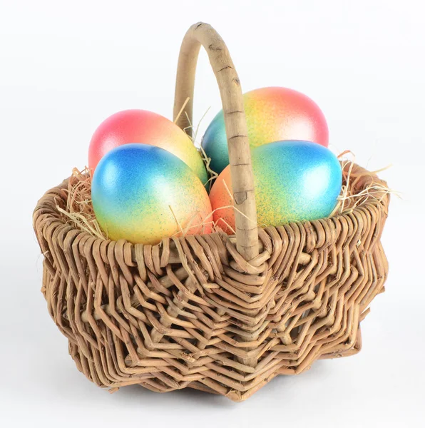 Colorful painted easter eggs in brown basket — Stock Photo, Image