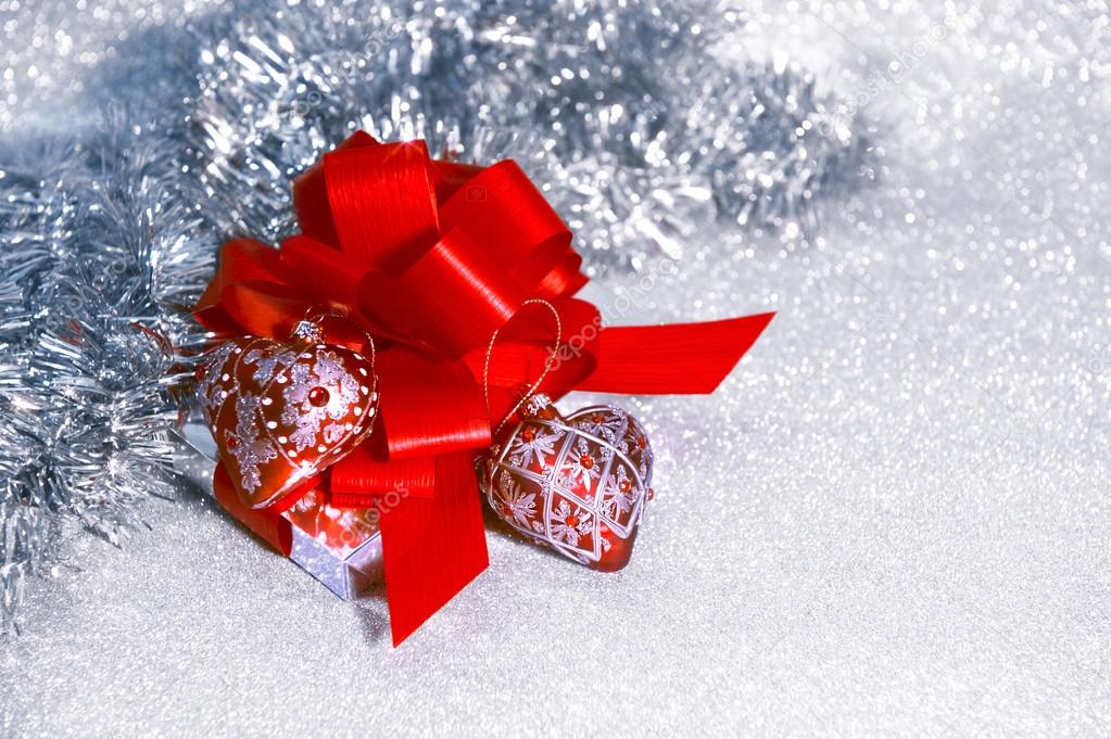 Christmas gift with red ribbon on shiny background