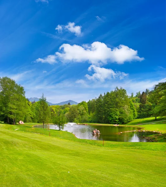 Зеленое поле для гольфа с голубым небом — стоковое фото
