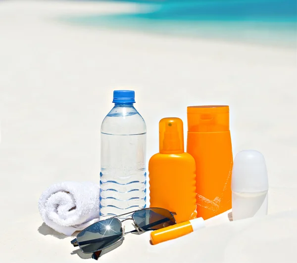 Wasser und Sonnenschutz Creme am Strand Hintergrund — Stockfoto