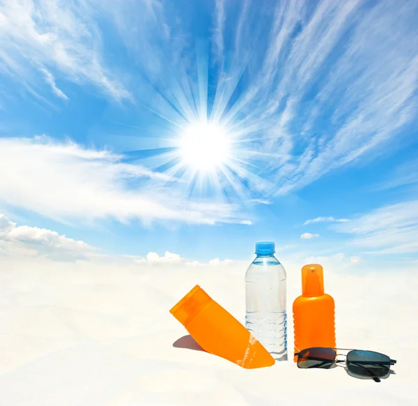 Su ve güneş koruması gökyüzü arka plan üzerinde krem — Stok fotoğraf