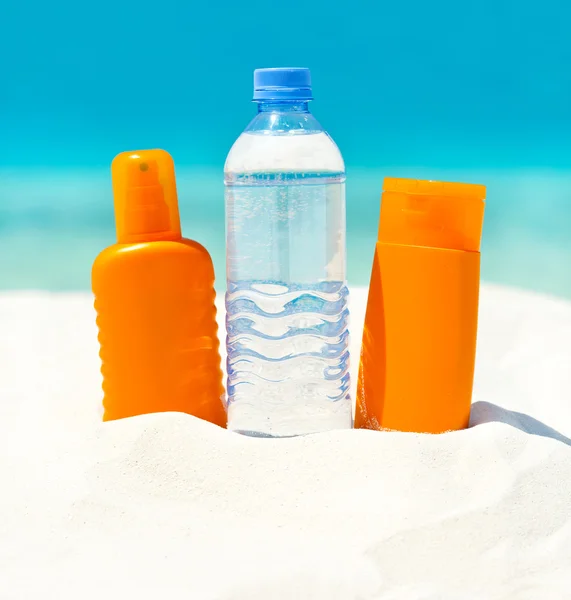 水と太陽の保護クリームの砂のビーチ — ストック写真