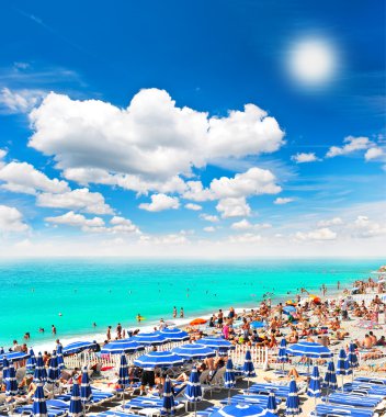 turistler, şezlong ve şemsiye sıcak yaz gününde