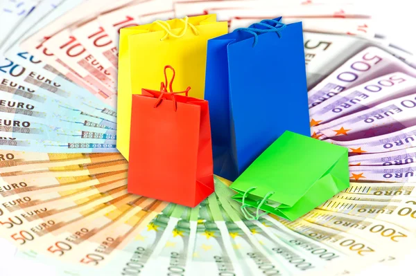 Shopping bags over euro currency banknotes — Stock Photo, Image