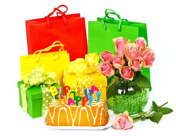 Narozeninový dort se svíčkami, květinami a dárky — Stock fotografie