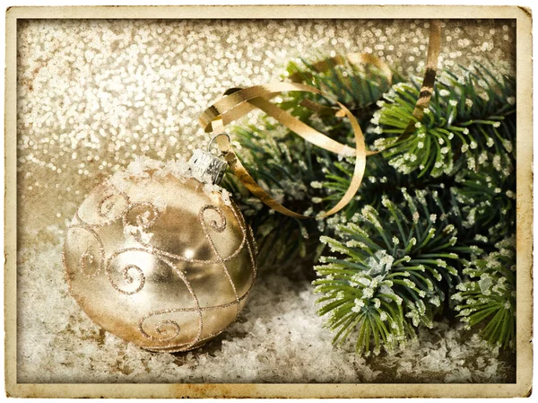 Goldene Weihnachtskugel mit Christbaumzweig — Stockfoto