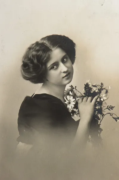 Молодая сентиментальная женщина с цветами — стоковое фото