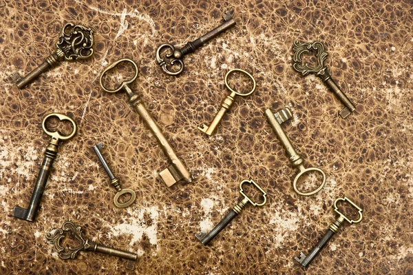 Old golden keys over vintage paper background — Stock Photo, Image