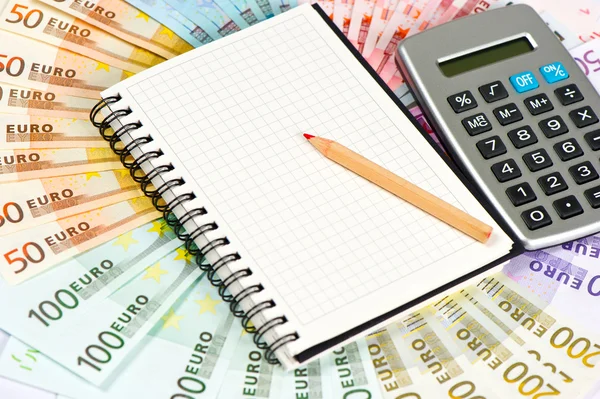 Calculator and note book on euro banknotes — Stock Photo, Image