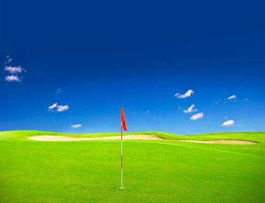 Mavi gökyüzü arka plan ile yeşil golf alanı
