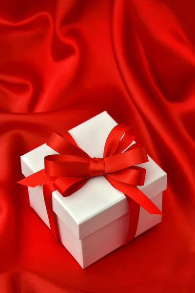 Confezione regalo bianca con nastro rosso su seta — Foto Stock