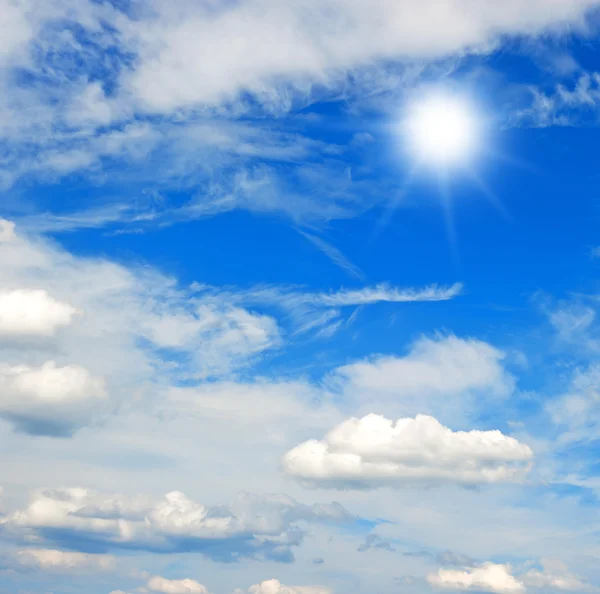Krásná modrá obloha s mraky a sluncem — Stock fotografie