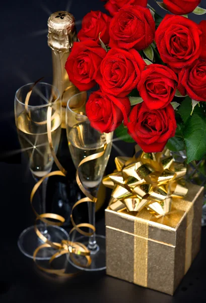 Κόκκινα τριαντάφυλλα, χρυσή δώρο και και σαμπάνια — Φωτογραφία Αρχείου