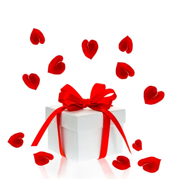 Подарункова коробка з цибулею червоної стрічки та пелюстками троянд — стокове фото