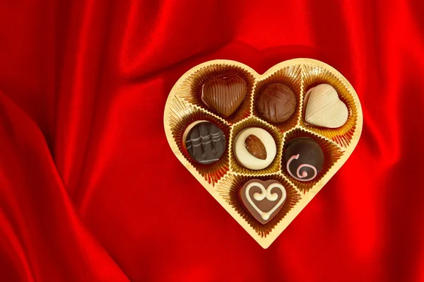 Chocolate pralines in golden heart shape gift box — Stock Photo, Image