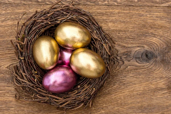 Uova di Pasqua in nido su sfondo di legno vintage — Foto Stock