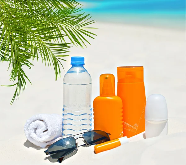 Wasser und Sonnenschutz Creme am Strand Hintergrund — Stockfoto