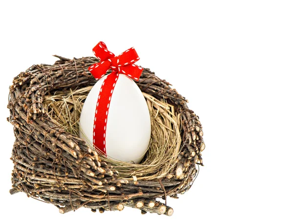 Белое пасхальное яйцо с красной лентой бант украшения — стоковое фото