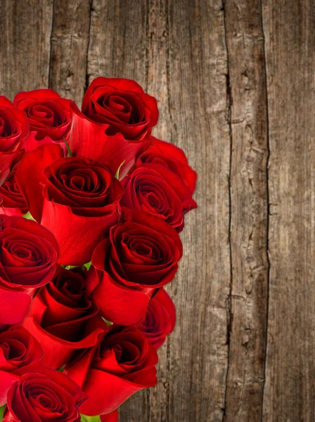 Ramo de rosas rojas sobre fondo de madera —  Fotos de Stock