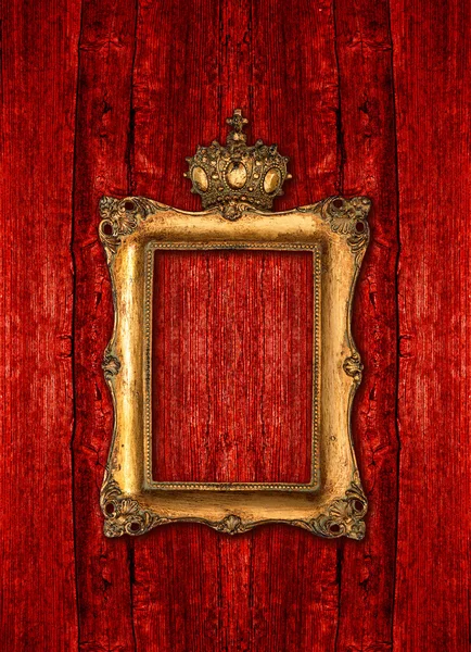 Golden frame with crown over red wooden background — Stock Photo, Image