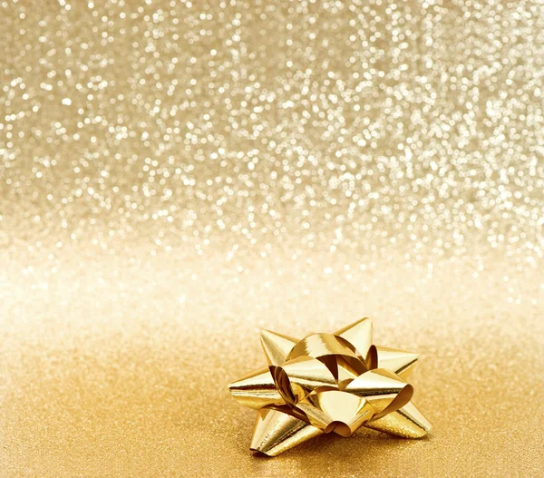 Golden ribbon bow on shiny background — Stock Photo, Image