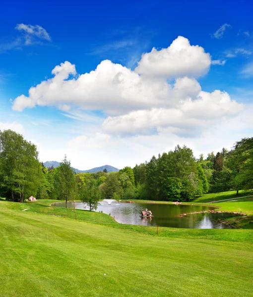 Campo de golfe com belo céu azul e lago — Fotografia de Stock