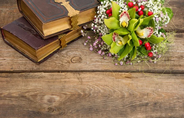 Bouquet of orchid flowers and old books — Stock Photo, Image