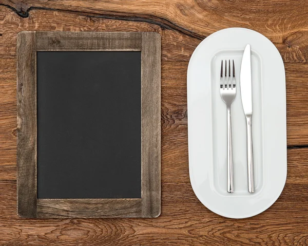 Blackboard for menu on wooden table — Stock Photo, Image