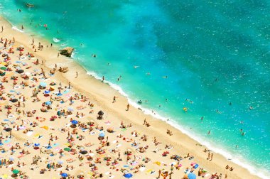 turistler, şezlong ve şemsiye ile plaj