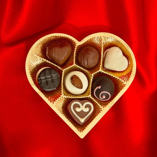 Chokladpraliner i gyllene hjärta form presentförpackning — Stockfoto