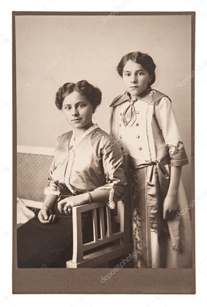 Portrait of mother with daughter wearing vintage clothing