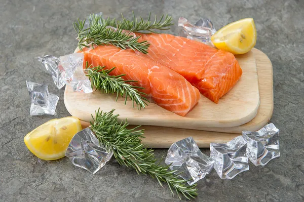 Filetto di salmone crudo con erbe fresche di rosmarino, limone e ghiaccio — Foto Stock