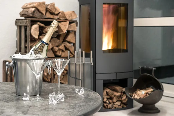 Festive home interior wirh champagne, two glasses and fireplace — Stock Photo, Image