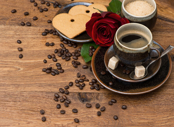 Cup of black coffee with red rose flower and heart cake